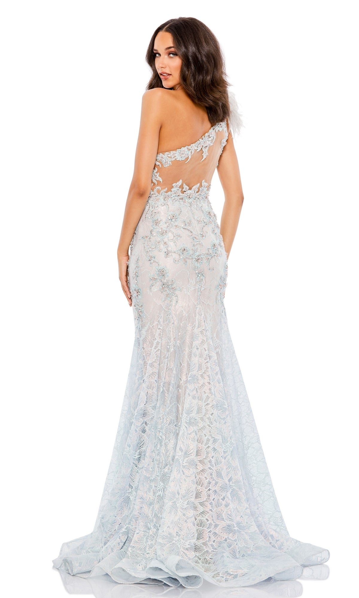 A woman poses in a light blue feather one-shoulder mermaid prom gown with a sheer back and long train, echoing the elegance of the Mac Duggal 79264 beaded evening dress.